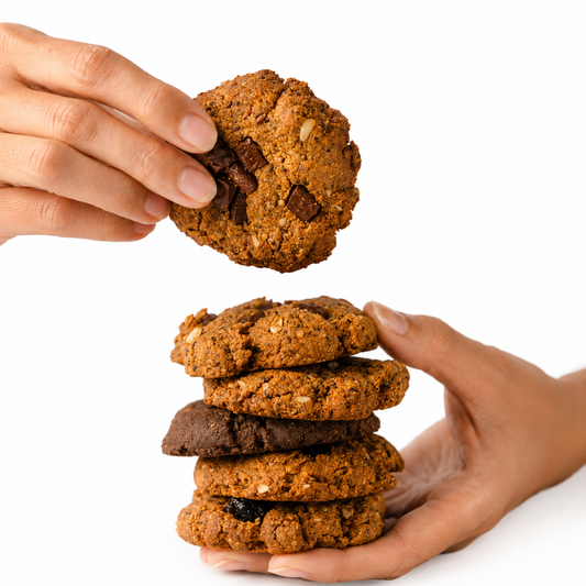 Hand reaching for a cookie above a stack of cookies on a white background