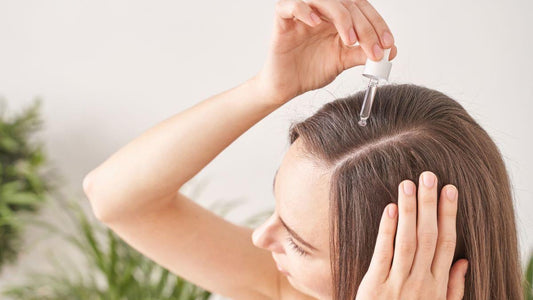 Woman applying sesame oil to her scalp as part of a hair care routine.