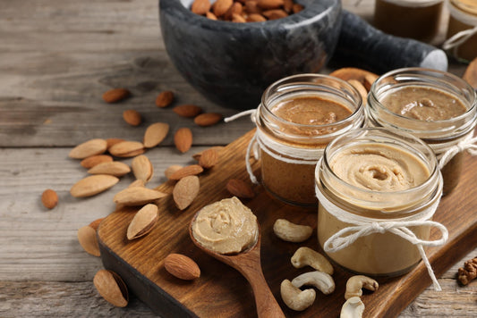 Homemade nut butter in glass jars with almonds and cashews