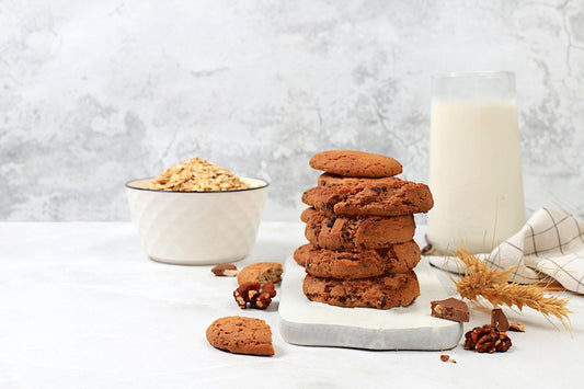Stack of healthy cookies with oats and milk, illustrating a healthier cookie snack option