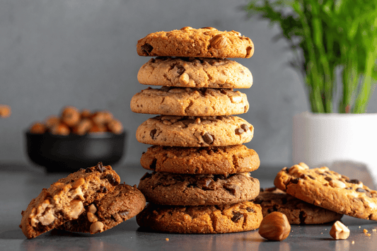 Stack of different cookie varieties, including chocolate chip, nut, and oat cookies, illustrating how cookie type and size affect calorie content.