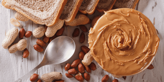 Natural peanut butter served with roasted peanuts and whole grain bread highlighting its protein, healthy fats, and fibre.