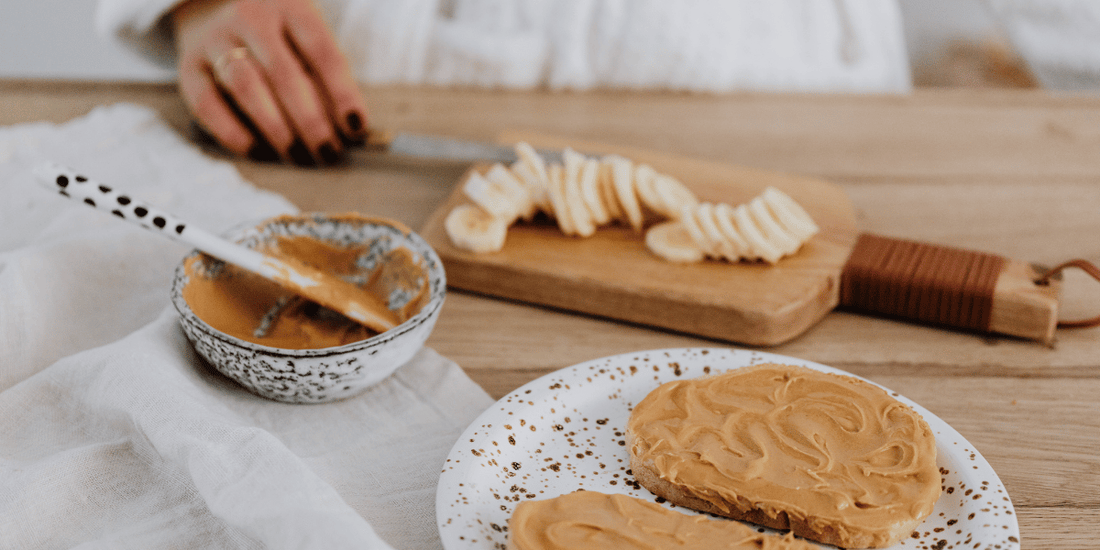 Natural peanut butter spread on toast with sliced banana, showing a balanced breakfast for calorie-conscious eating.