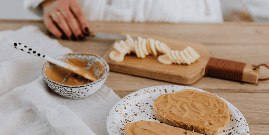 Natural peanut butter spread on toast with sliced banana, showing a balanced breakfast for calorie-conscious eating.