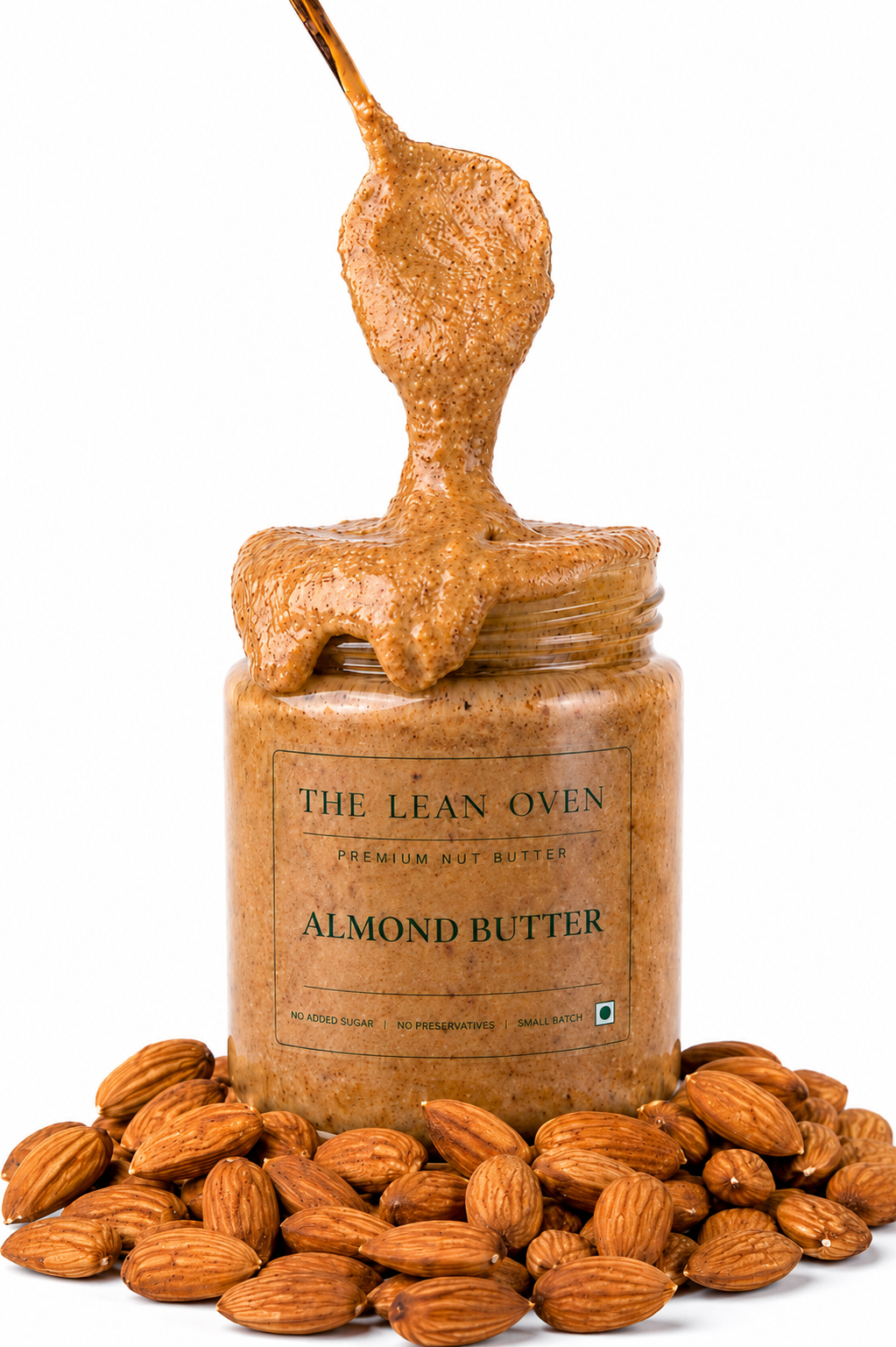 Jar of almond butter with a spoonful above, surrounded by almonds on a white background